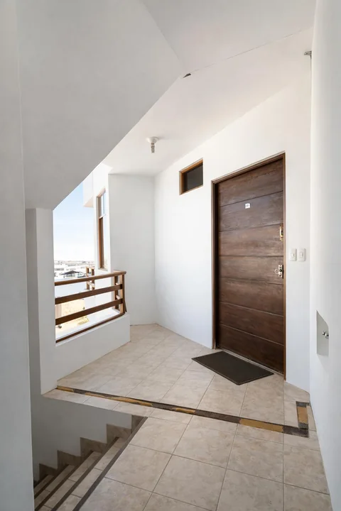 Acceso interior con escalera y puerta de madera