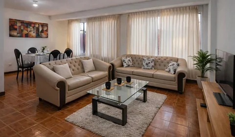 Sala amplia con sofás y comedor al fondo